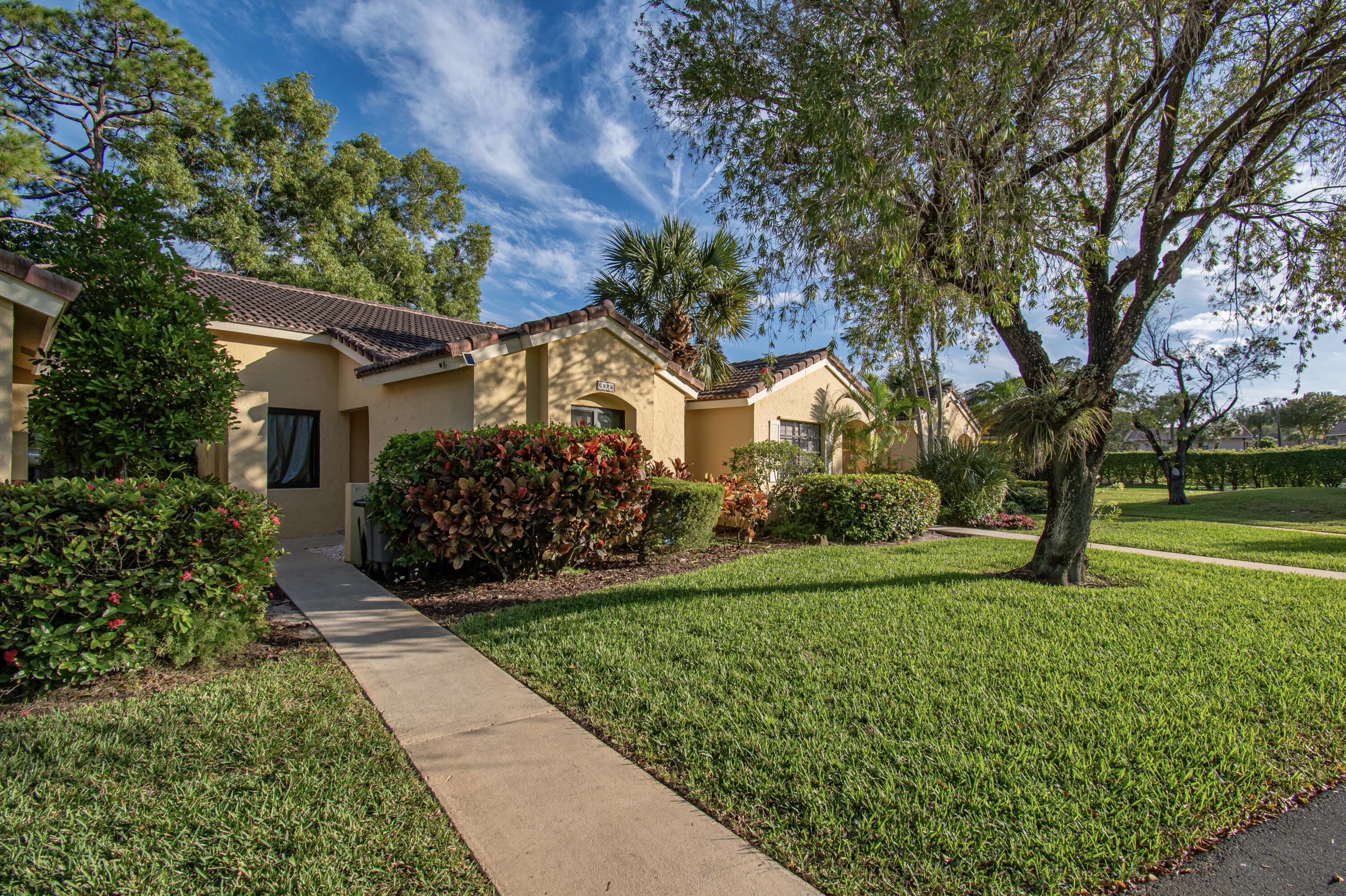 a view of a house with a big yard and large trees
