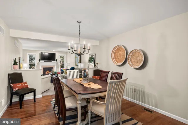 a view of a dining room with furniture a chandelier and wooden floor