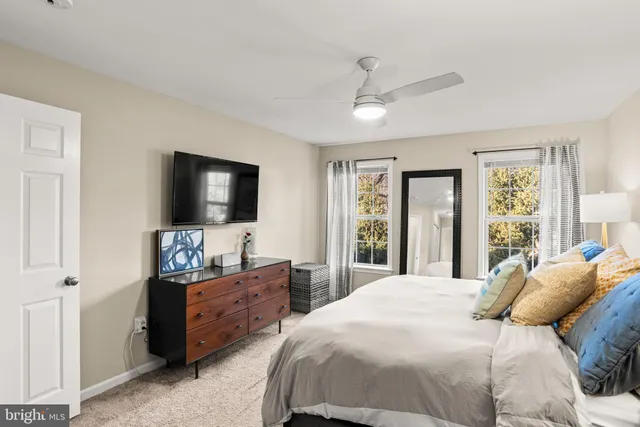 a bedroom with a bed and a flat screen tv on dresser