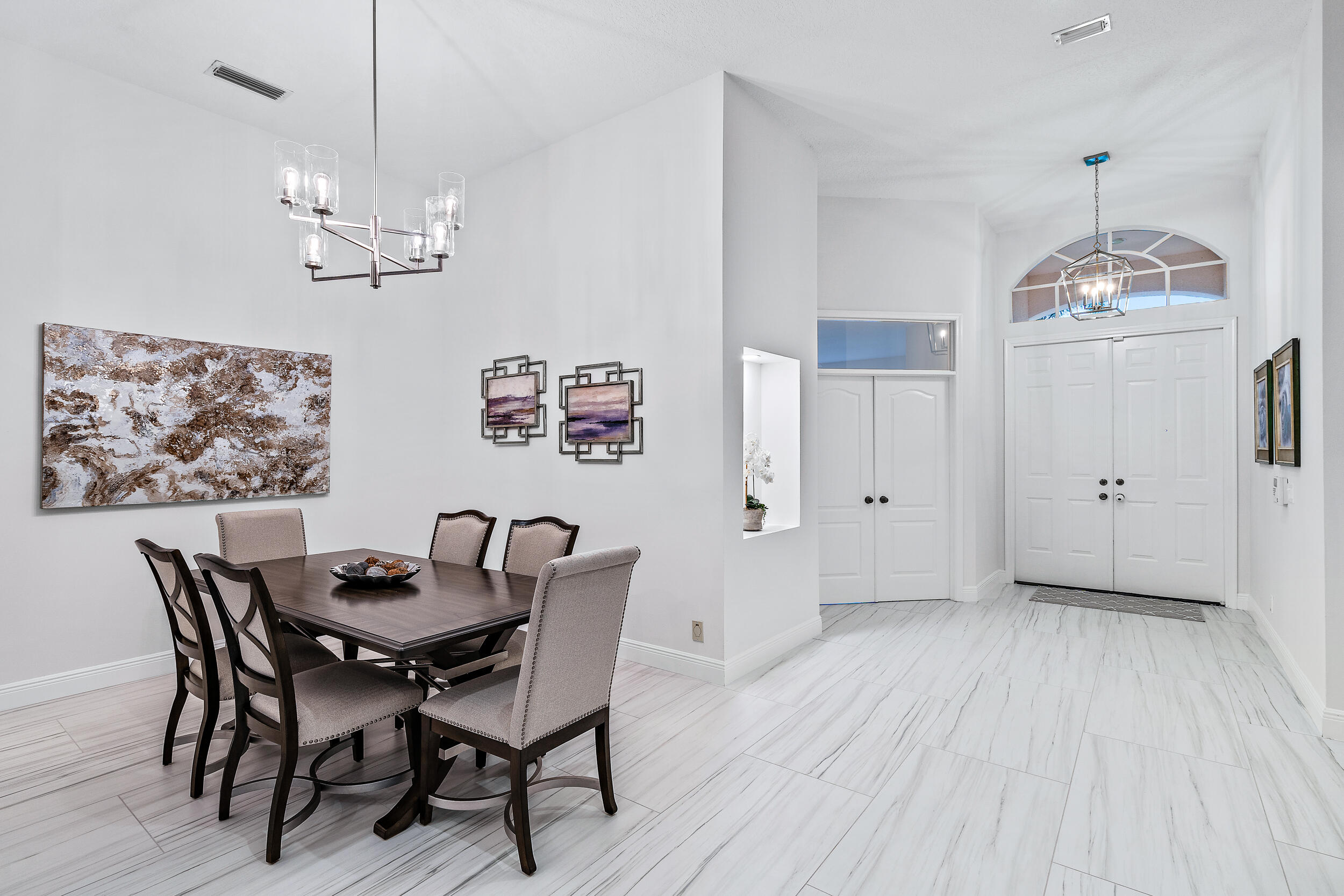 207 Eagleton Estates Boulevard Palm Beach Gardens, FL 33418 - Photo 12 of 34 a view of a dining room with furniture wooden floor and chandelier
