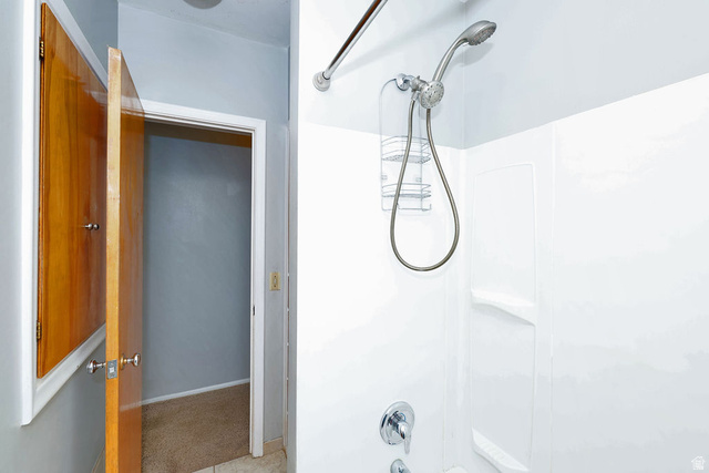 1272 Cook Street Ogden, UT 84404 - Photo 16 of 46 White shower surround with integrated shelves, chrome shower head, and a chrome single-handle faucet