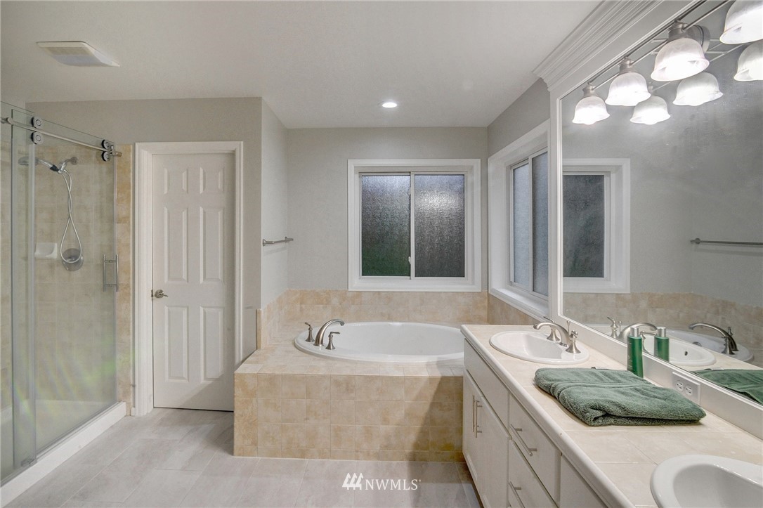 1217 South 36th Place Renton, WA 98055 - Photo 20 of 30 a bathroom with a granite countertop double vanity sink mirror and shower