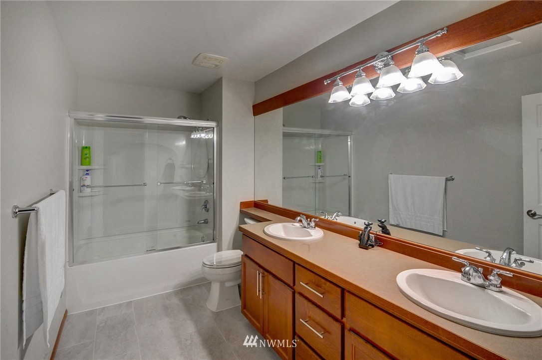 1217 South 36th Place Renton, WA 98055 - Photo 28 of 30 a bathroom with a sink double vanity granite tub and shower