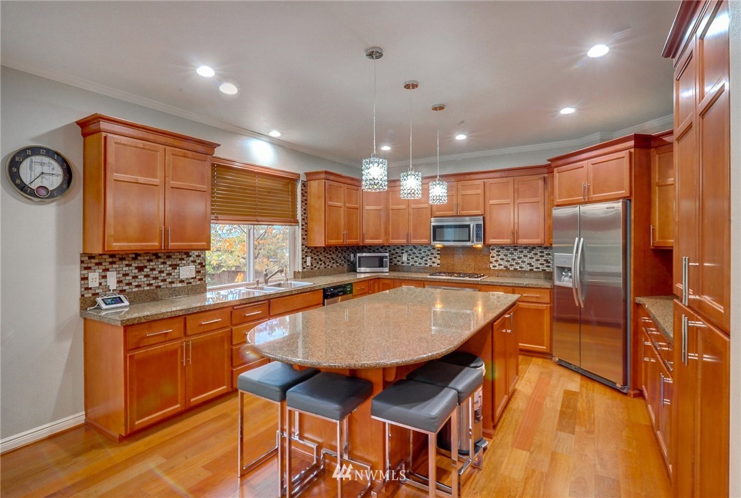 1217 South 36th Place Renton, WA 98055 - Photo 8 of 30 a kitchen with stainless steel appliances granite countertop a sink and a refrigerator