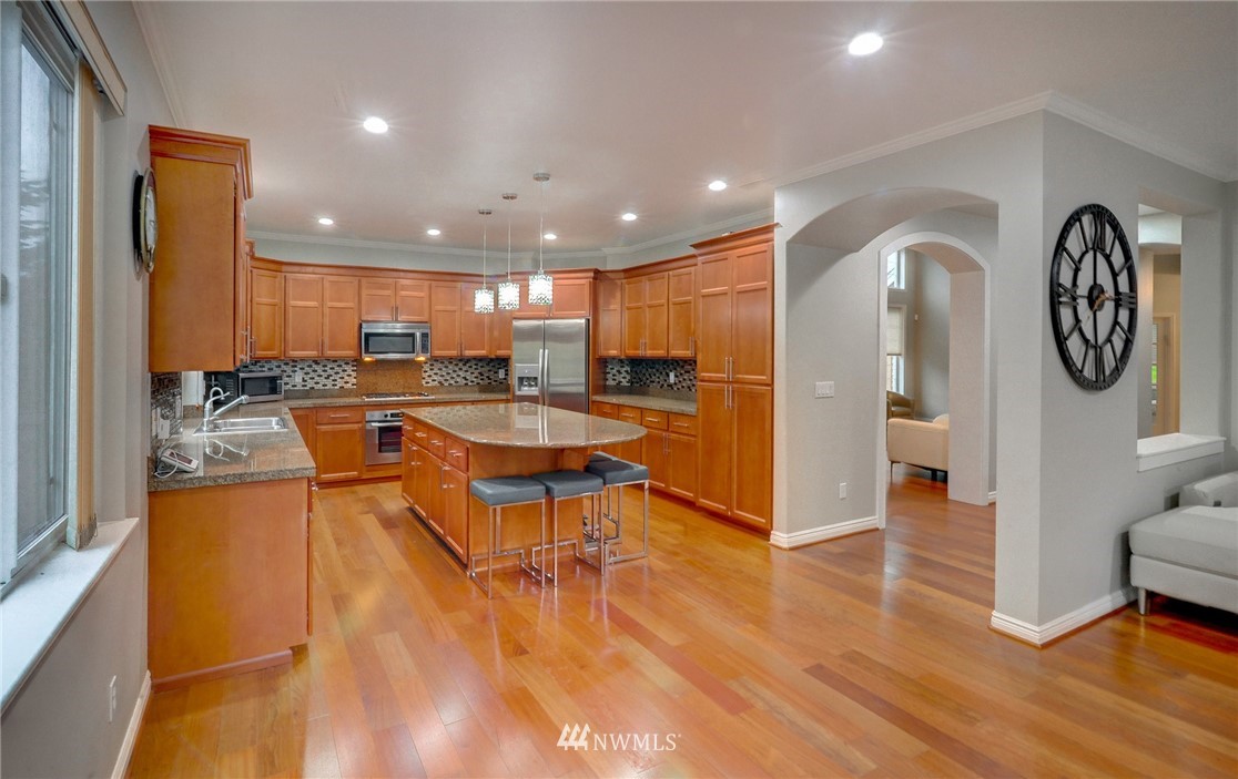 1217 South 36th Place Renton, WA 98055 - Photo 10 of 30 a living room with stainless steel appliances furniture a large window and a wooden floor