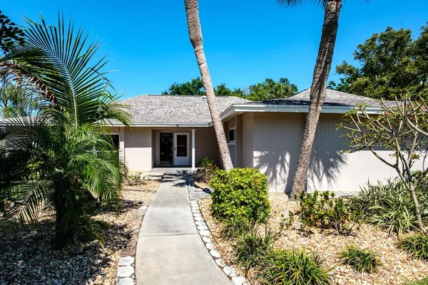 a view of an empty room with wooden floor and a kitchen