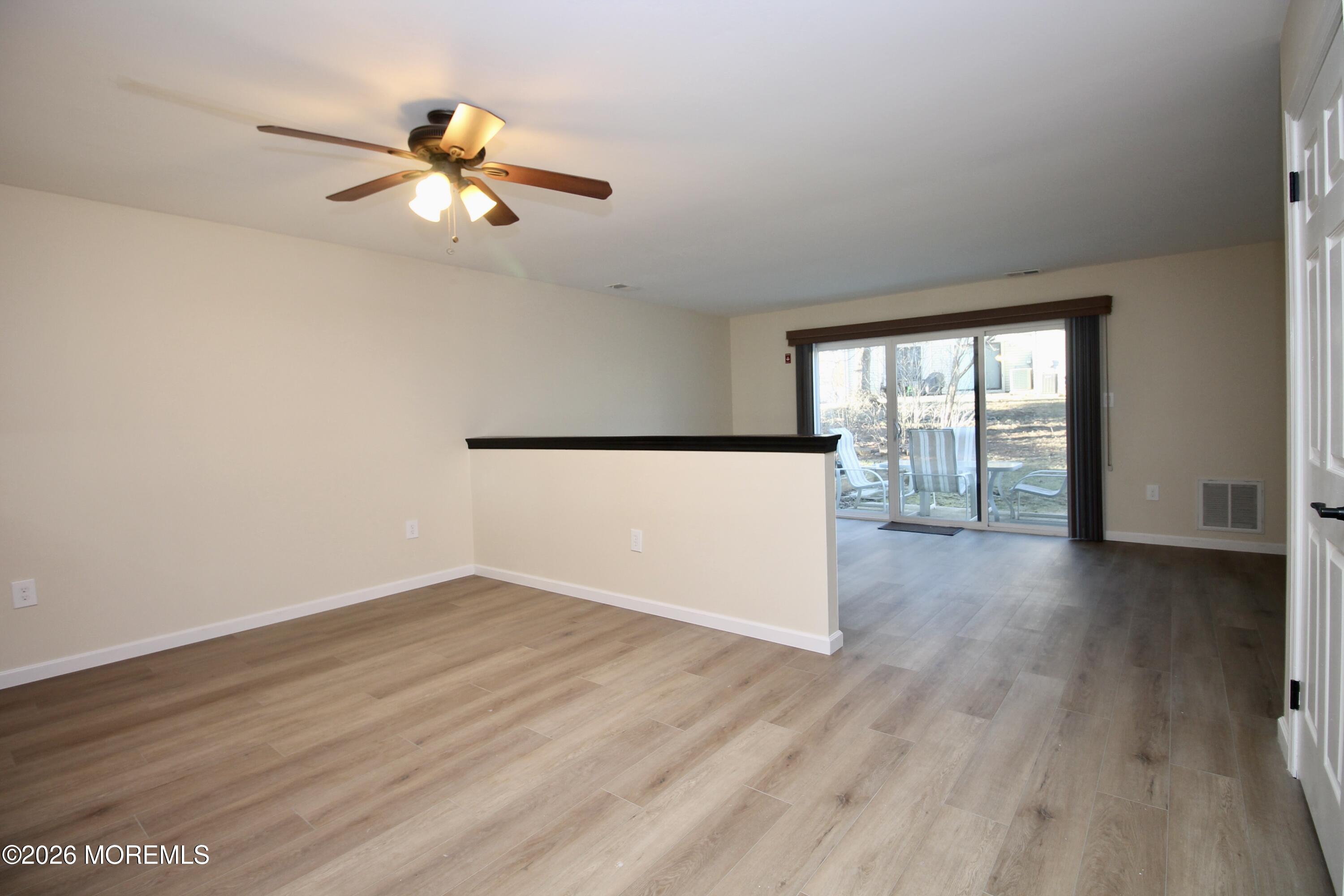 5-2 Claridge Court, Unit 2 Freehold, NJ 07728 - Photo 14 of 35 an empty room with wooden floor and windows
