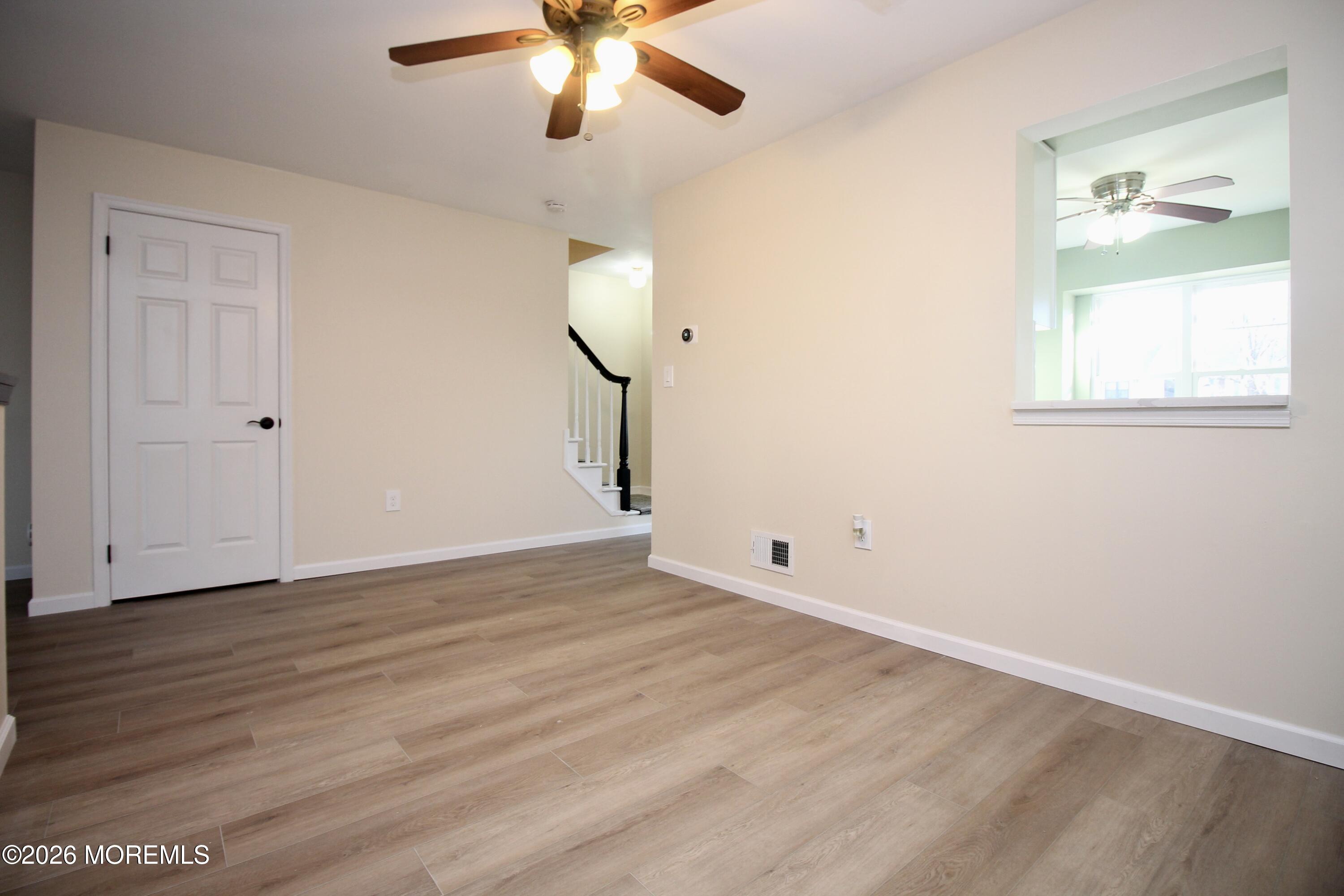 5-2 Claridge Court, Unit 2 Freehold, NJ 07728 - Photo 16 of 35 an empty room with wooden floor fan and windows