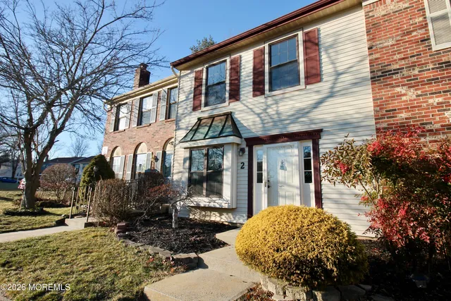 a view of a white house with large windows next to a road