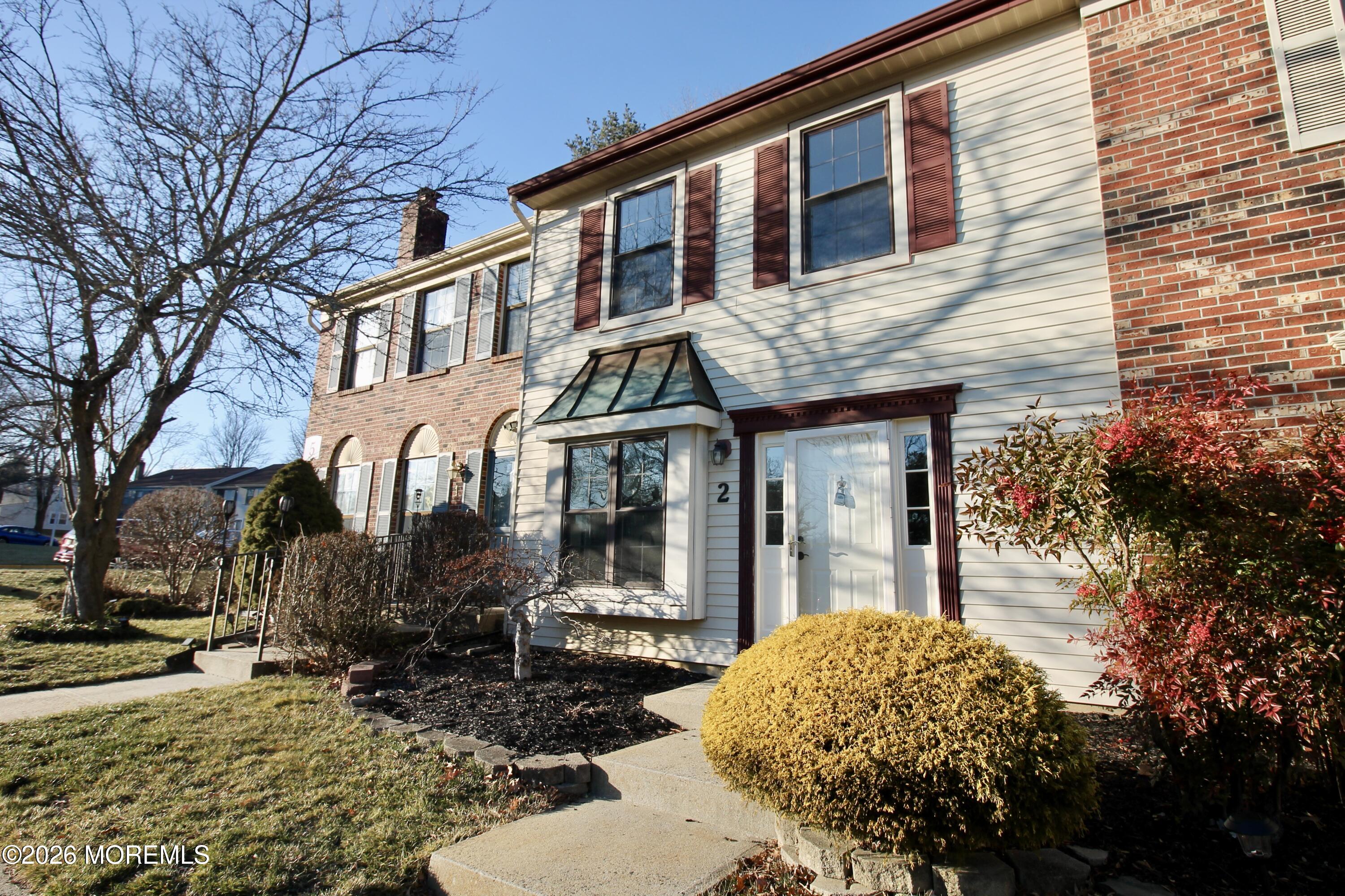 5-2 Claridge Court, Unit 2 Freehold, NJ 07728 - Photo 2 of 35 a view of a white house with large windows next to a road