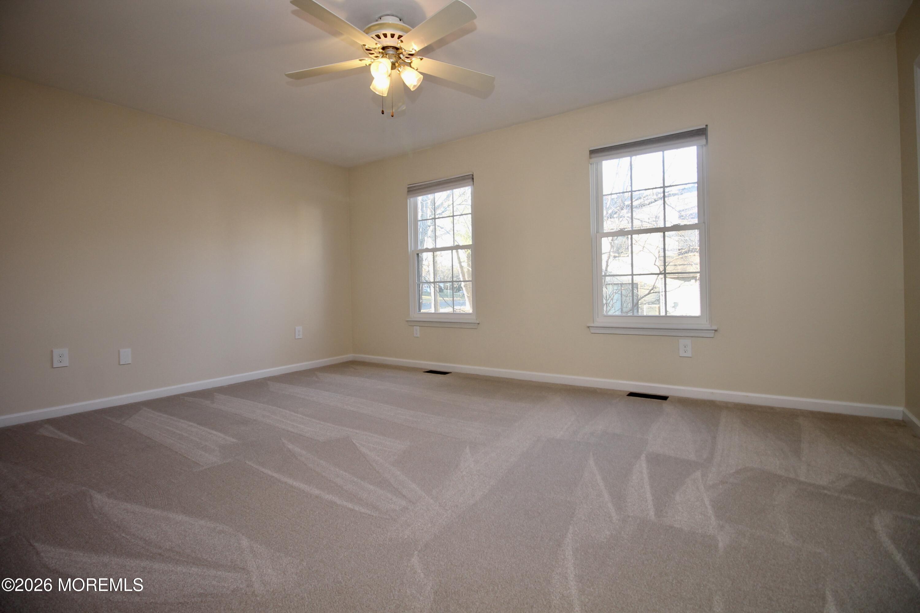 5-2 Claridge Court, Unit 2 Freehold, NJ 07728 - Photo 24 of 35 an empty room with windows and fan