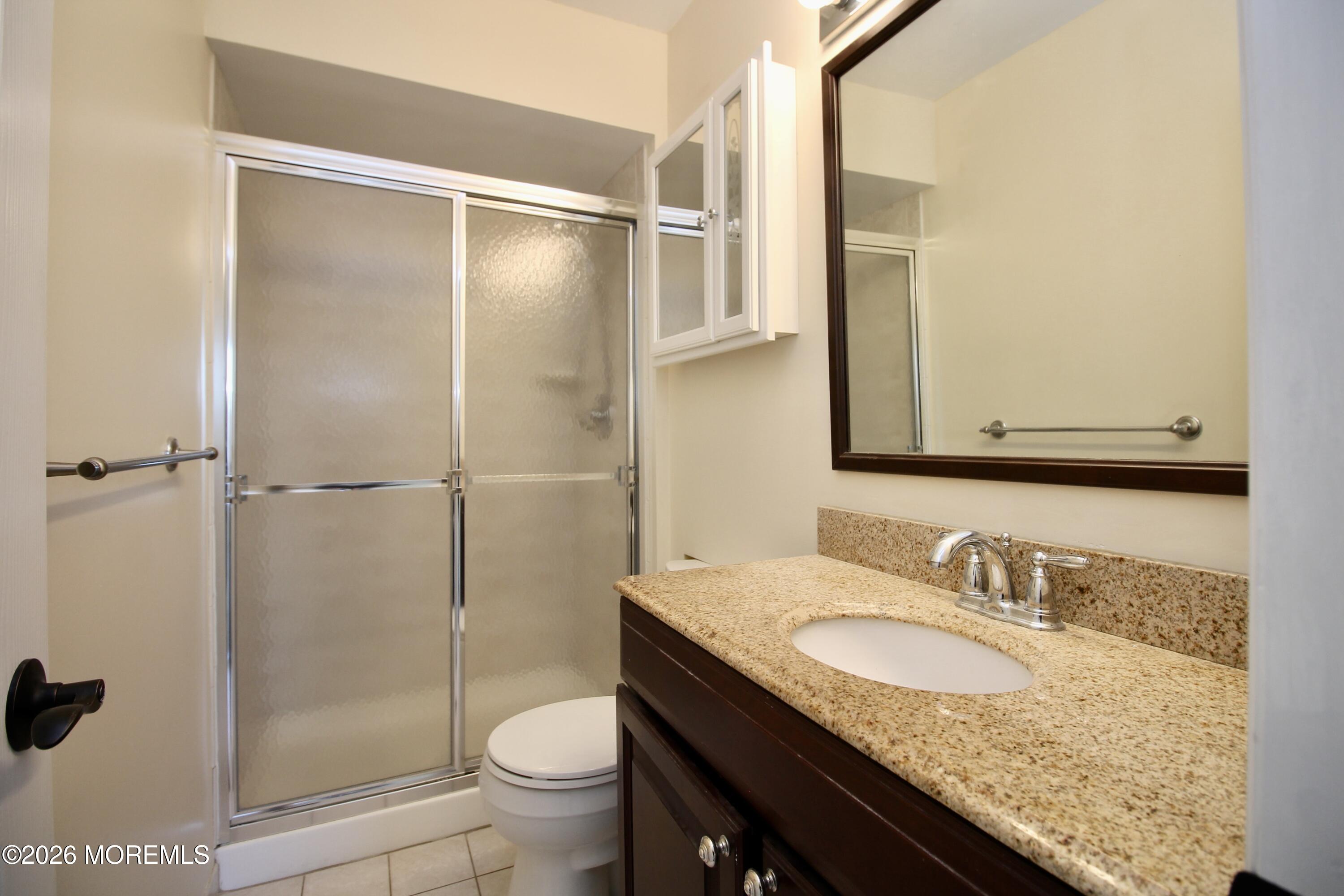 5-2 Claridge Court, Unit 2 Freehold, NJ 07728 - Photo 30 of 35 a bathroom with a granite countertop sink toilet and shower