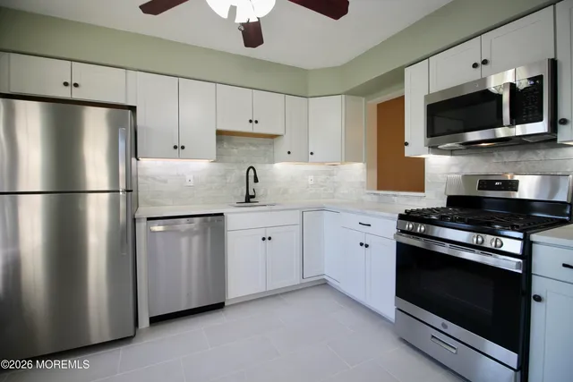 a kitchen with stainless steel appliances a refrigerator sink and microwave