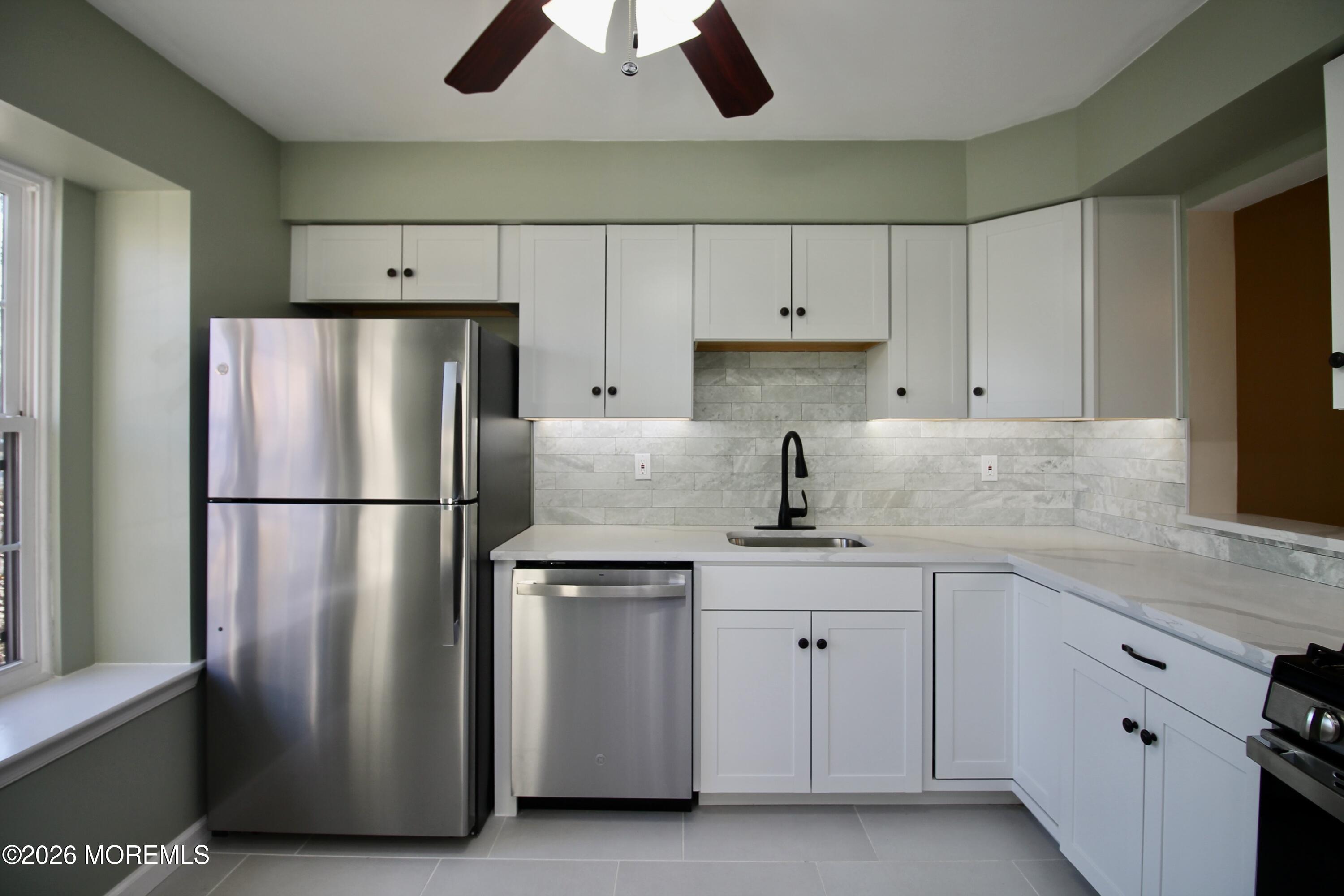 5-2 Claridge Court, Unit 2 Freehold, NJ 07728 - Photo 10 of 35 a kitchen with white cabinets and stainless steel appliances