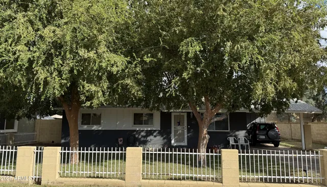 a front view of house with green trees