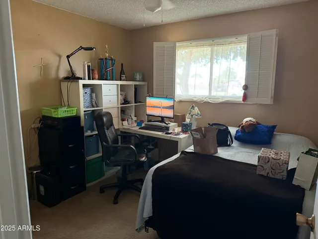 a bedroom with a bed a desk and a window