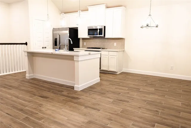 a kitchen with a sink cabinets and wooden floor