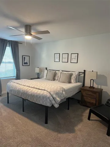 a bedroom with a large bed and a chandelier