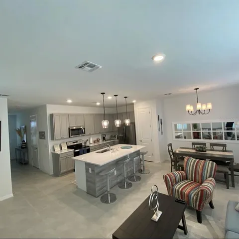 a kitchen with a refrigerator a stove a sink dishwasher with a dining table and chairs