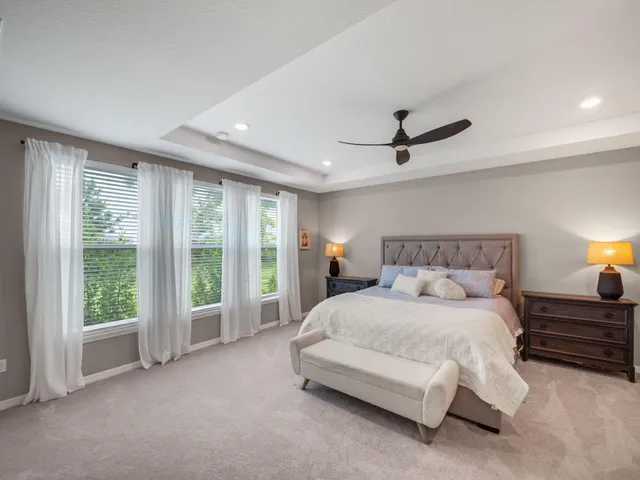 a spacious bedroom with a bed and a ceiling fan