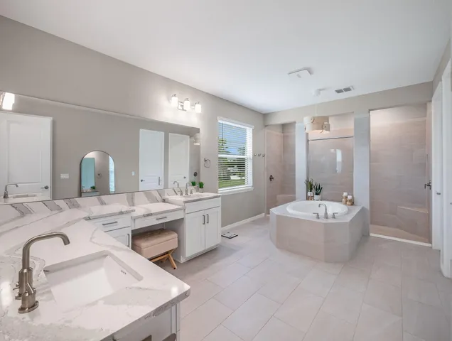 a large bathroom with a double vanity sink mirror and bathtub