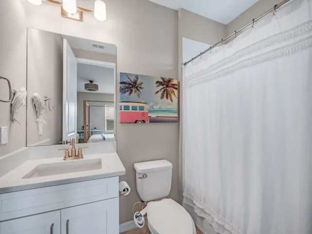 a bathroom with a sink a toilet and shower curtain