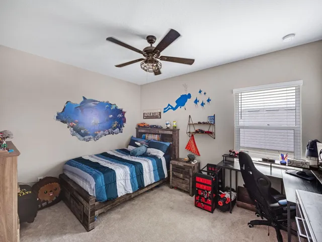a bedroom with furniture a ceiling fan and a window