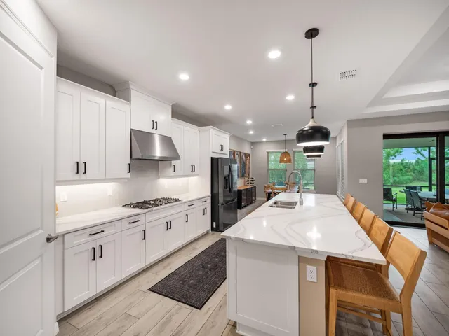 a large kitchen with kitchen island a sink stainless steel appliances and cabinets
