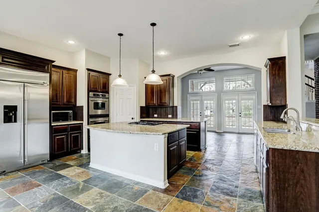 a kitchen with stainless steel appliances granite countertop a stove and a sink