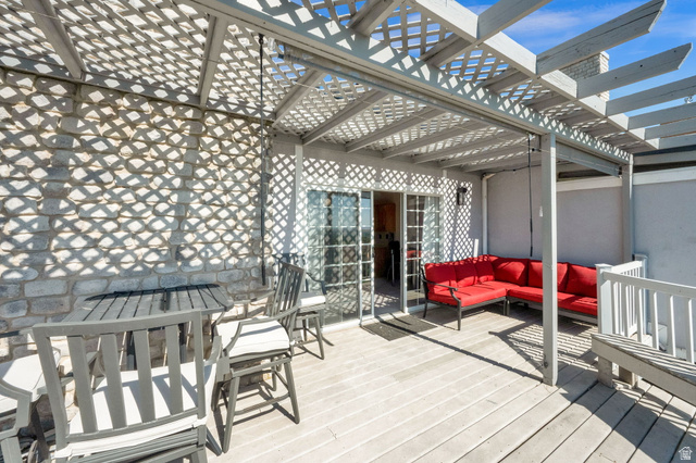 5057 South Ridgedale Drive Ogden, UT 84403 - Photo 12 of 69 Rooftop deck featuring a slatted pergola, durable decking, stone wall, and sliding glass doors