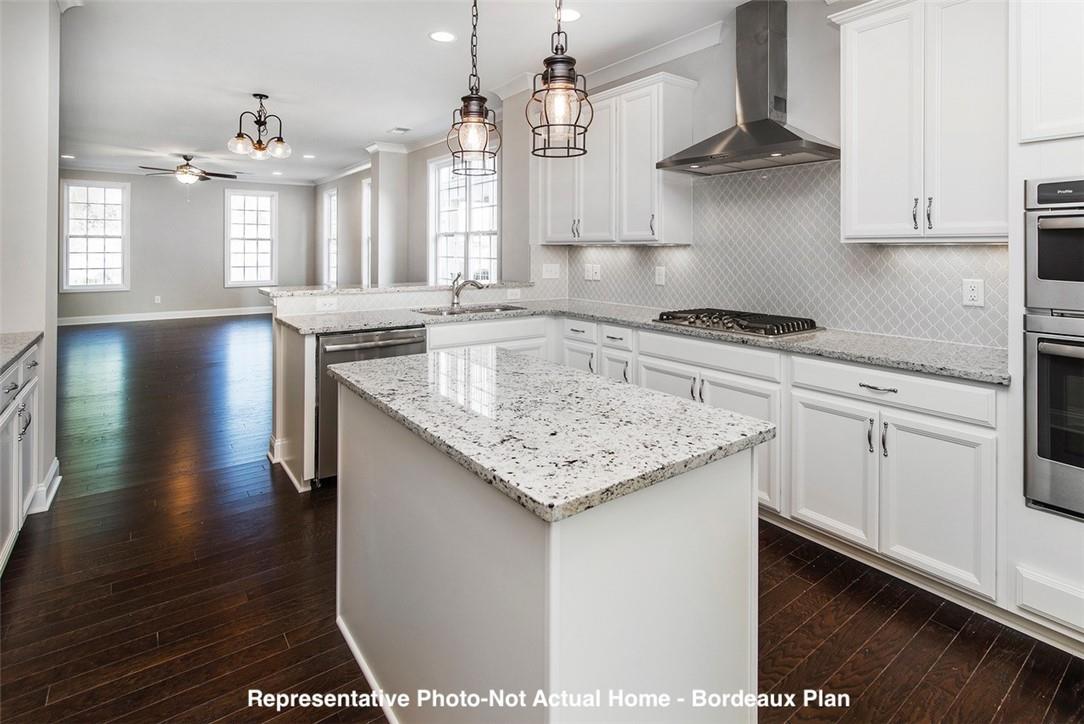 10175 Rainier Trail Drive Northwest Huntersville, NC 28078 - Photo 6 of 18 a kitchen with a sink dishwasher a stove and white cabinets with wooden floor
