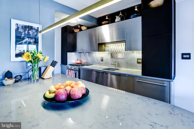 a dining hall with stainless steel appliances granite countertop a sink and a refrigerator