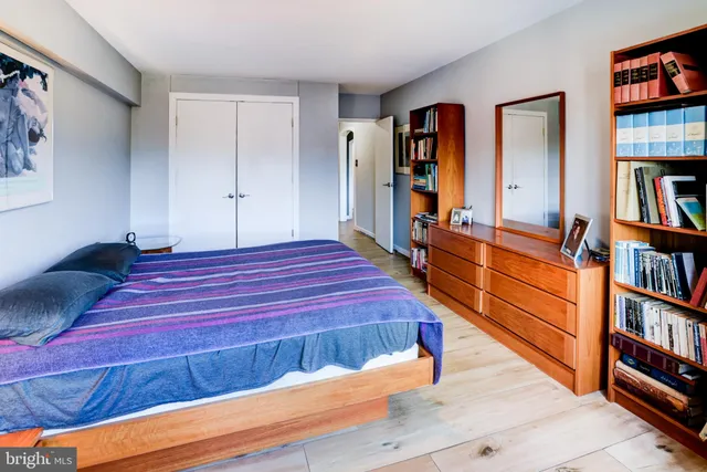 a bedroom with a bed and a painting on the wall