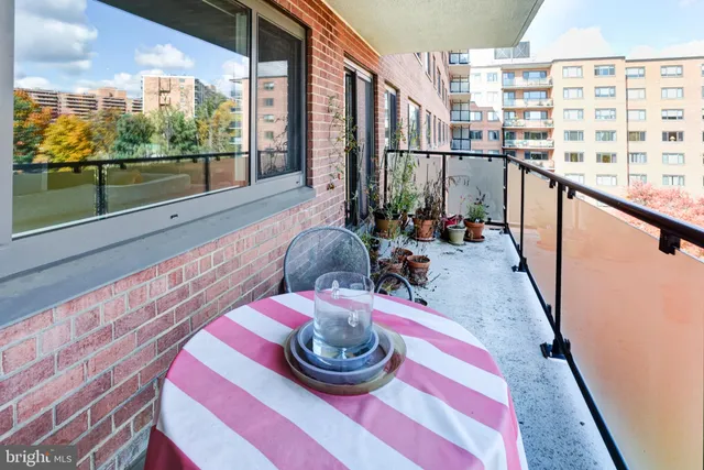 a view of a swimming pool with a bench and trees in the background