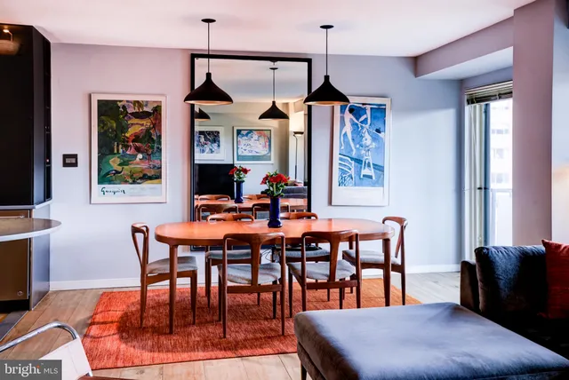 a dining room with furniture a chandelier and wooden floor