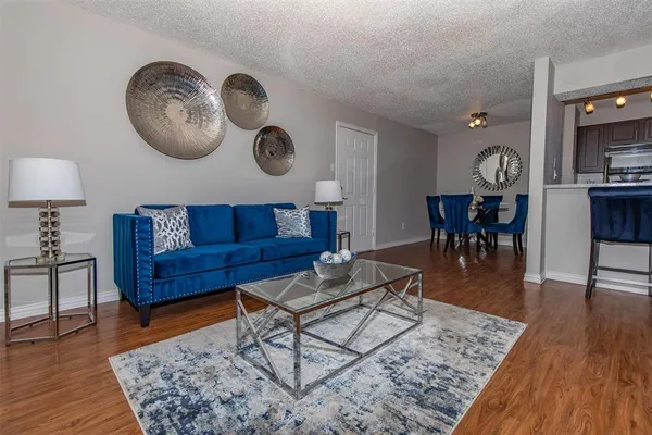 a living room with furniture a wooden floor and a bookshelf