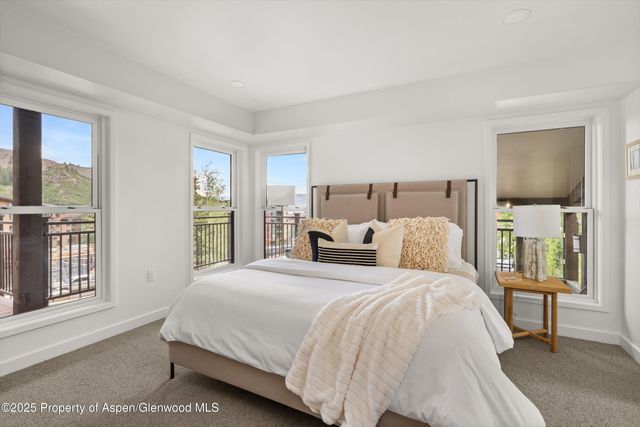 a bed sitting in a spacious bedroom next to a window