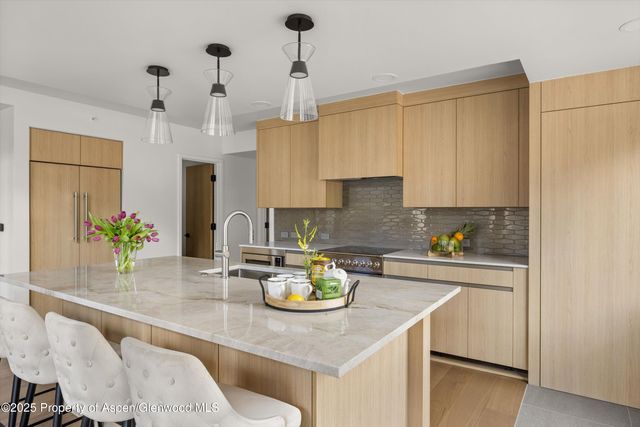a kitchen with a sink a kitchen island and stainless steel appliances