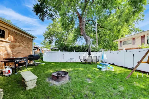 a view of a chair and table in backyard of the house