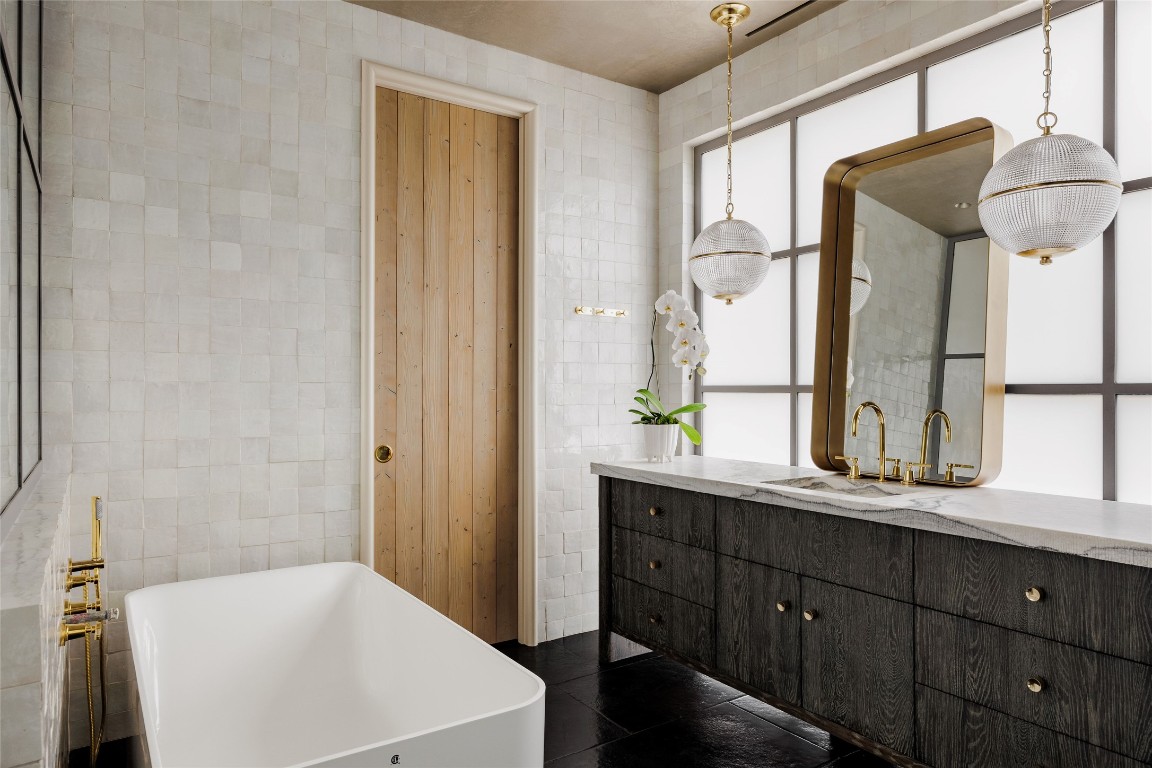2600 Tanglewood Trail Austin, TX 78703 - Photo 20 of 35 a en suite bathroom with a sink a mirror and a bathtub