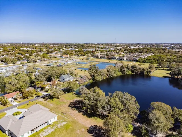 an aerial view of ocean and residential houses with outdoor space