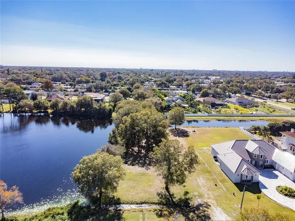 an aerial view of lake residential houses with outdoor space and trees