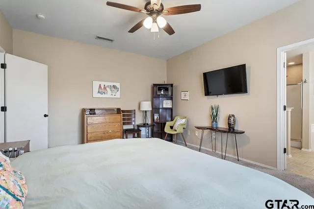 a bedroom with a bed and a flat tv screen on dresser
