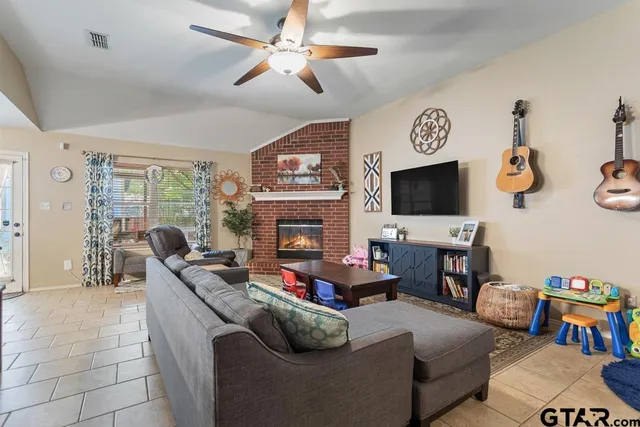 a living room with furniture a flat screen tv and a fireplace
