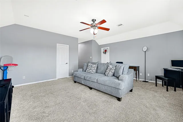 a living room with furniture and a ceiling fan