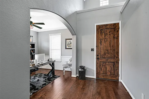 a view of a livingroom with wooden floor and a workspace