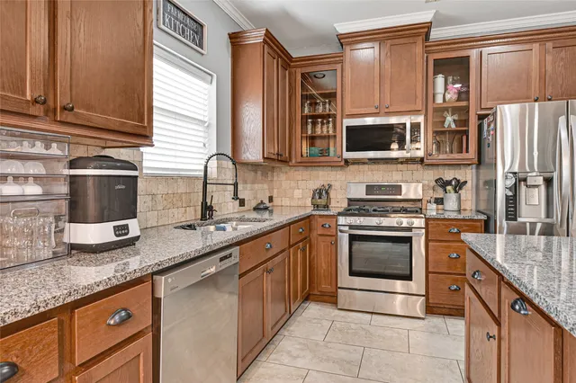 a kitchen with stainless steel appliances granite countertop a sink stove and refrigerator