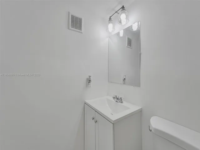 a bathroom with a sink a toilet and vanity