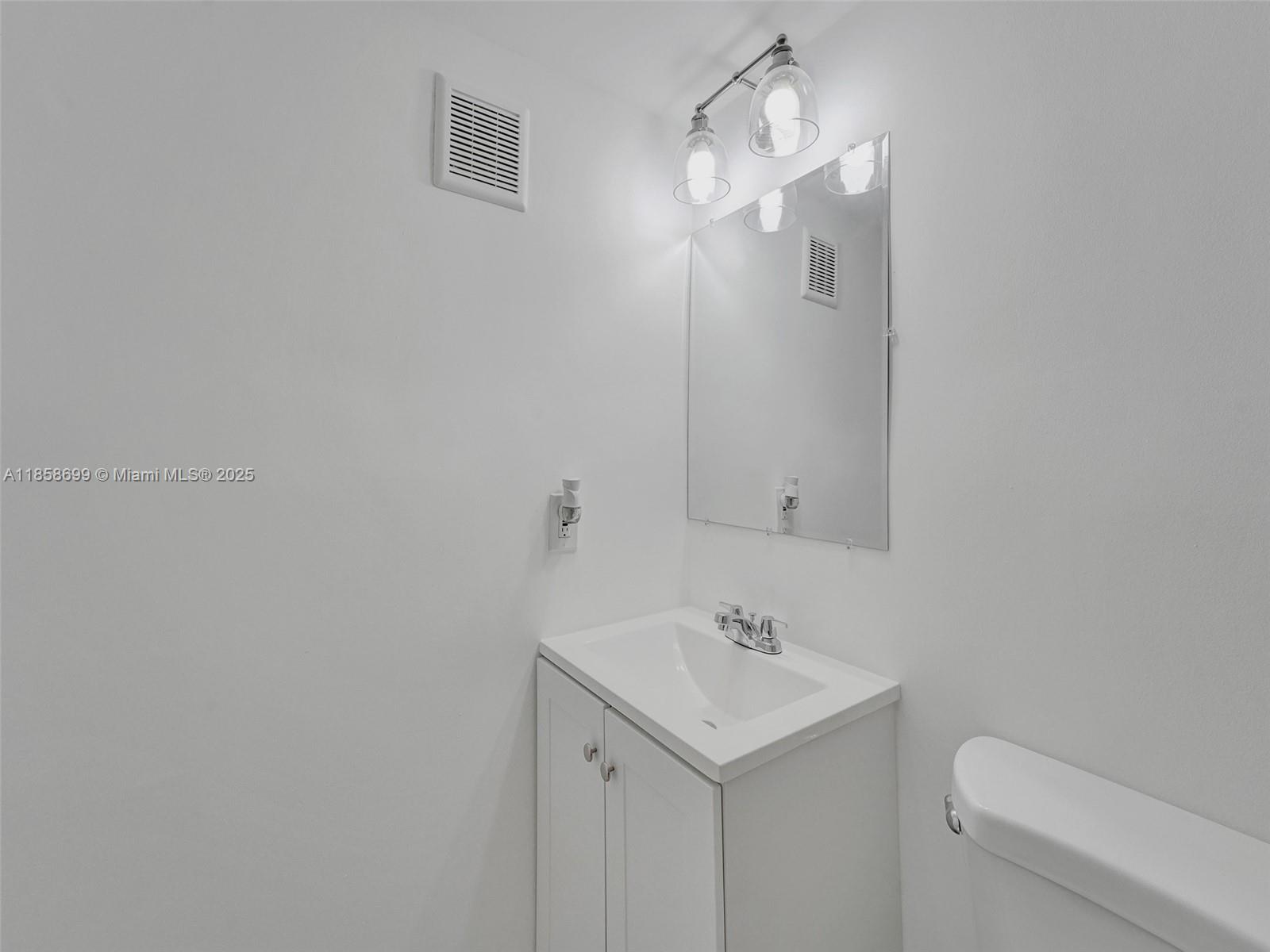 14190 West Dixie Highway, Unit 11 North Miami, FL 33161 - Photo 13 of 21 a bathroom with a sink a toilet and vanity
