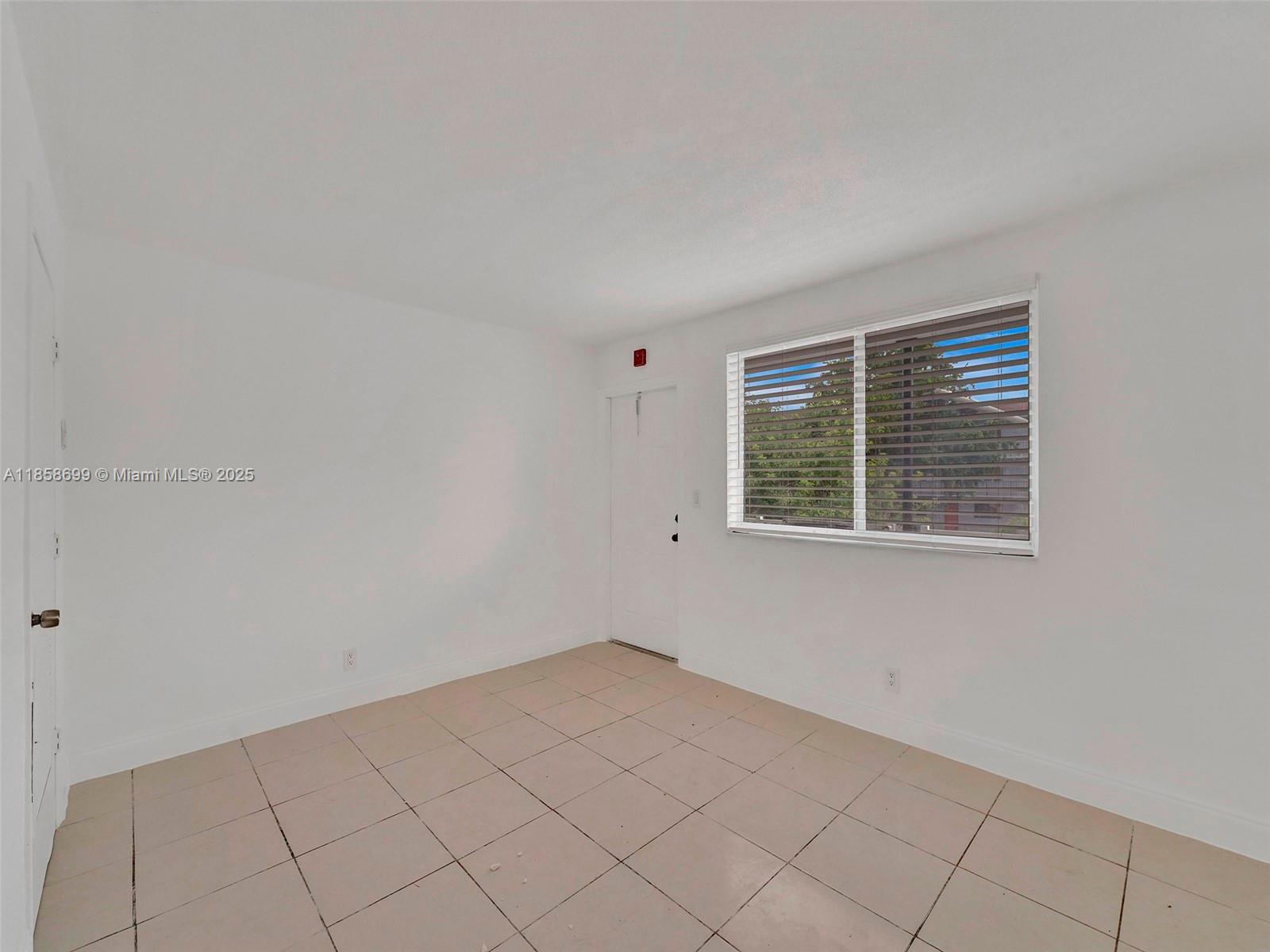 14190 West Dixie Highway, Unit 11 North Miami, FL 33161 - Photo 16 of 21 a view of an empty room with a window